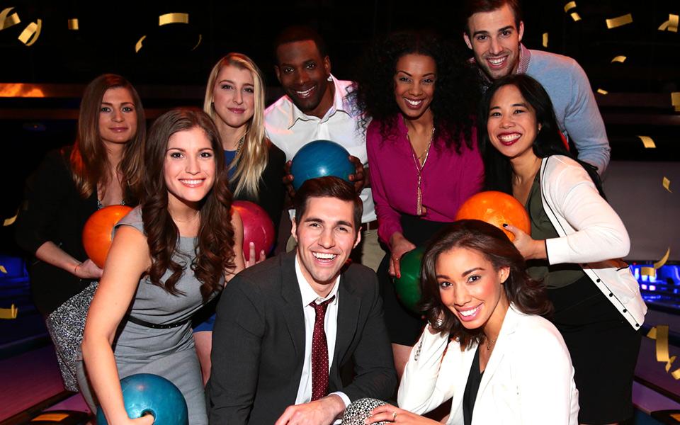 Group of bowlers huddled around person in suit