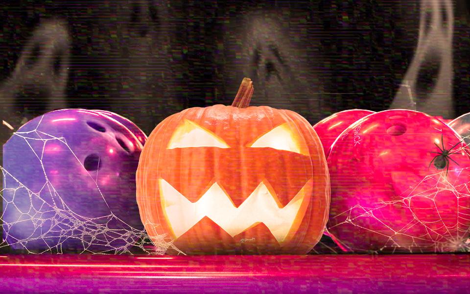 Halloween pumpkin surrounded by glowing bowling balls.