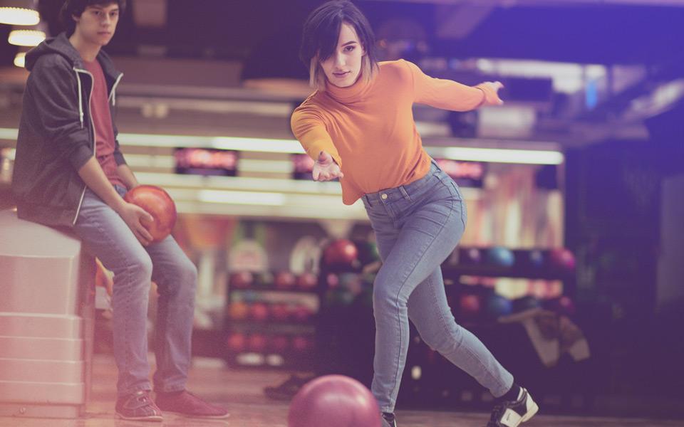 Woman throwing bowling ball down the lane